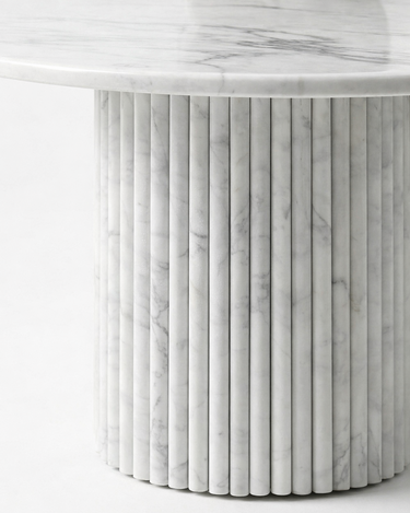 Close-up of Margot marble coffee table fluted cylindrical base in White Volakas marble showing vertical grooves and natural grey veining detail