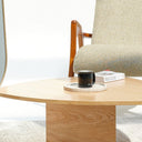 Modern interior with a tall mirror, wooden coffee table, and armchair.