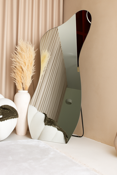 Solis frameless irregular standing mirror with sculptural shape in modern interior