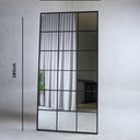 Vian full length standing mirror with black metal grid frame leaning against wall