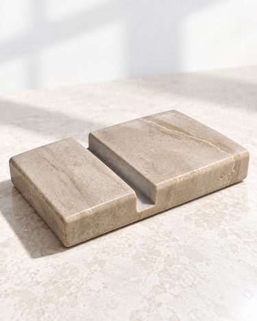 Serpeggiante Marble phone holder with a recessed phone slot, angled view