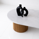 Sculptural oval coffee table with fluted wood pedestal bases