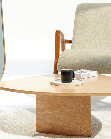 Modern interior with a tall mirror, wooden coffee table, and armchair.