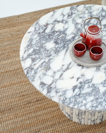 Contemporary round marble coffee table with sculptural base