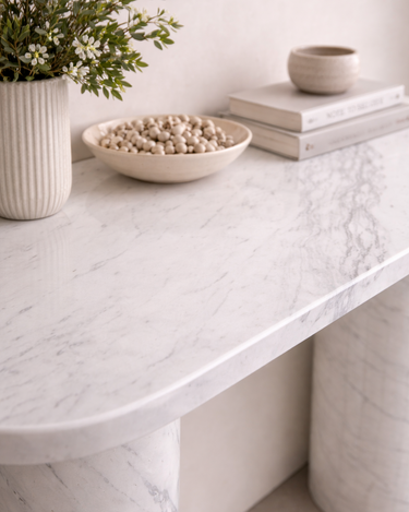 Evelyn White Volakas marble console table top styled with decor, highlighting smooth oval edges and polished stone surface