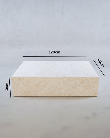 Low-profile marble coffee table in warm beige tones