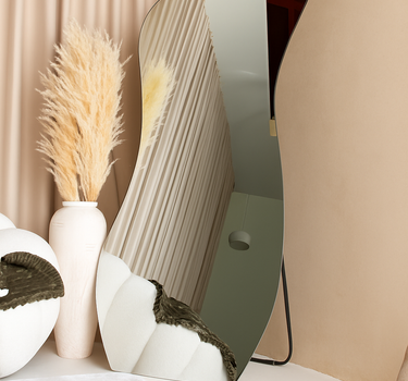 Solis frameless irregular standing mirror with sculptural shape in modern interior