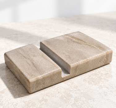 Serpeggiante Marble phone holder with a recessed phone slot, angled view